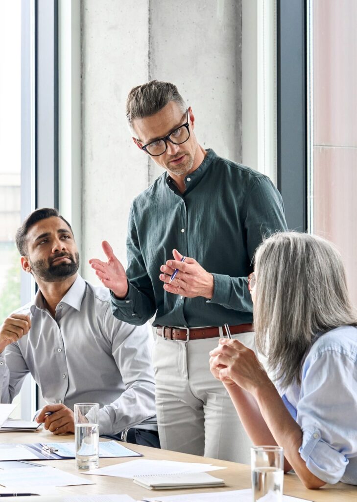 three business sales executives wearing workwear having a meeting 